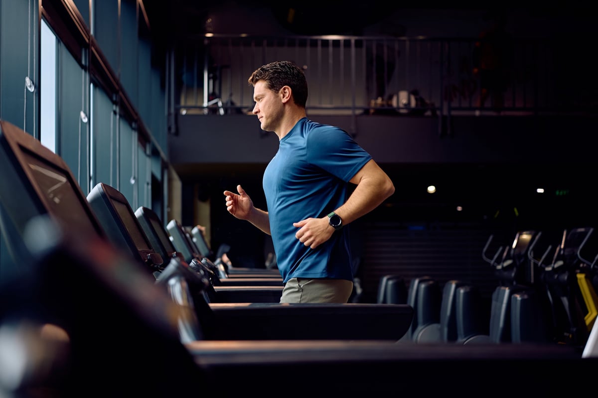 Dedicated athlete exercising on running track at fitness center